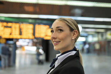 Nachdenkliche weibliche Flugbegleiterin, die am Flughafen wegschaut - JCCMF02884