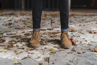 Junger Mann mit Schuhen auf dem Fußweg stehend - AFVF08871