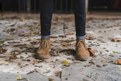 Young man wearing shoes standing on footpath - AFVF08871