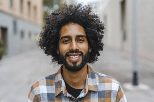 Young man with afro hairstyle smiling - AFVF08914