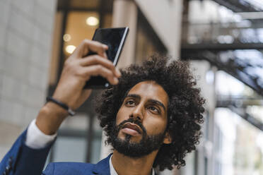 Businessman taking selfie through smart phone - AFVF08918