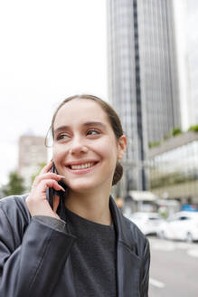 Lächelnde Unternehmerin, die wegschaut, während sie mit einem Mobiltelefon spricht - IFRF00870