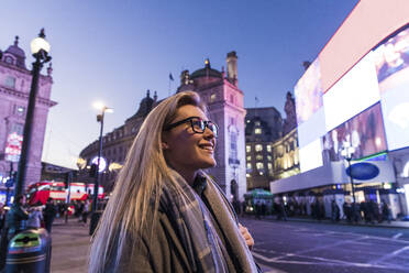 Lächelnde blonde Frau mit Brille auf der Straße stehend - WPEF04834