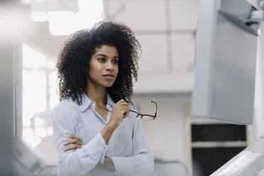 Afro-Frau mit Brille, die in der Industrie untersucht - KNSF08778