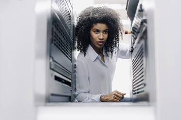 Businesswoman examining machinery in industry - KNSF08829