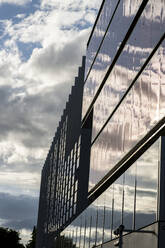 Spanien, Madrid, Wolken, die sich in der Glasfassade des Hauptsitzes von Repsol Campus spiegeln - JCCMF02902