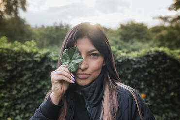 Frau hält sich Blatt vor das Auge - DSIF00435