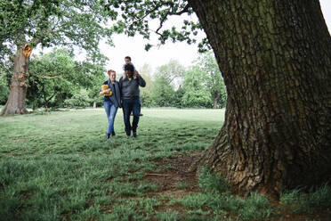 Vater und Mutter gehen mit ihrem Sohn im Park spazieren - ASGF00581