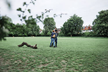 Family walking on grass in park - ASGF00583