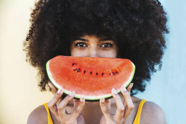 Junge Afro-Frau, die eine Scheibe Wassermelone hält - DAF00059