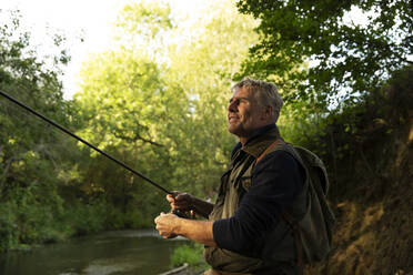 Gelassener Mann beim Fliegenfischen am Fluss - CAIF30688