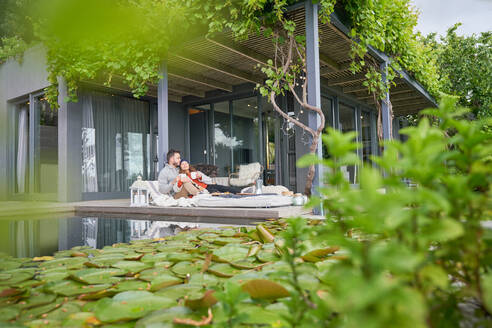 Verliebtes Paar entspannt sich bei Tee auf der Terrasse eines Luxushotels - CAIF30719
