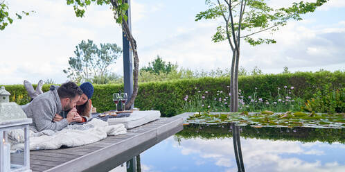 Zärtliches romantisches Paar entspannt sich auf der Terrasse eines Luxushotels - CAIF30727