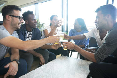 Diverse group of business people enjoying beers in office - CAIF30732