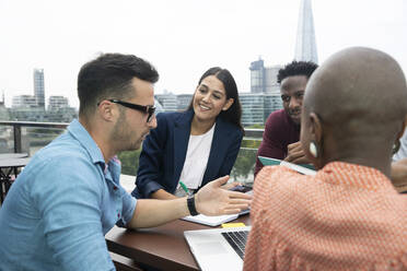 Geschäftsleute treffen sich auf dem Balkon eines städtischen Büros, London, UK - CAIF30734