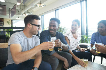 Happy business people celebrating with beers in office - CAIF30744