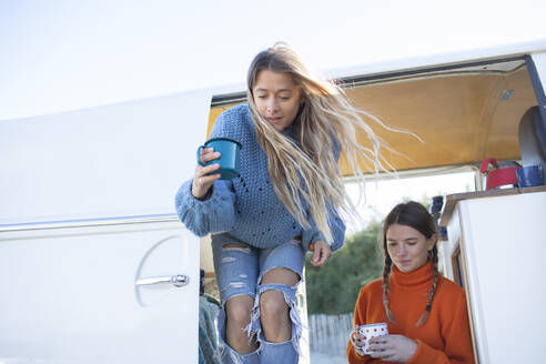 Junge Freundinnen trinken Kaffee im Wohnmobil - CAIF30750