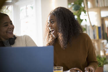 Happy mother and daughter using laptop - CAIF30819