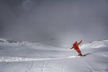 Mann Snowboarding auf Berg gegen Himmel im Urlaub - CAVF94194