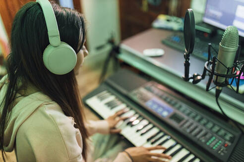 Musikerin spielt Klavier im Studio - JRVF01012