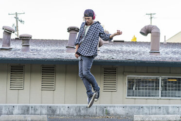 Man jumping while dancing near house - AFVF08929