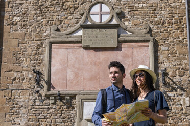 Touristenpaar mit Landkarte vor einer Backsteinmauer - EIF01178