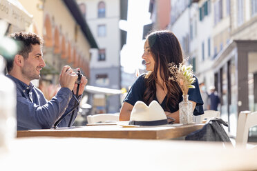 Männlicher Tourist fotografiert Frau in einem Straßencafé durch die Kamera - EIF01185