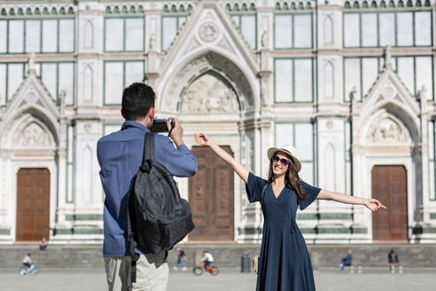 Mann fotografiert weibliche Touristin durch die Kamera vor der Basilika Santa Croce in Florenz, Italien - EIF01214