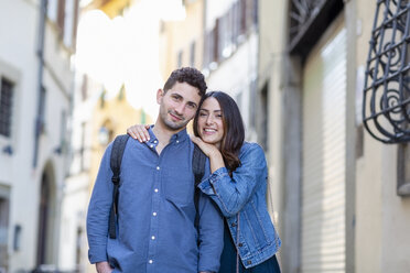 Couple smiling while standing together at city street - EIF01233