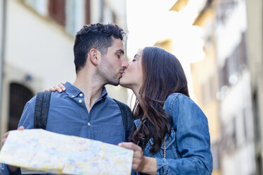 Couple holding map while kissing each other - EIF01236