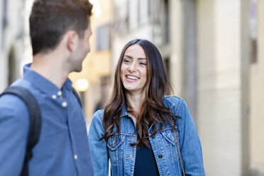 Young woman smiling while looking at man - EIF01237