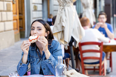 Weiblicher Tourist isst Pizza in einem Straßencafé - EIF01248
