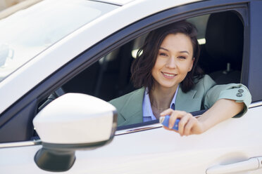 Smiling beautiful businesswoman sitting in car - JSMF02307