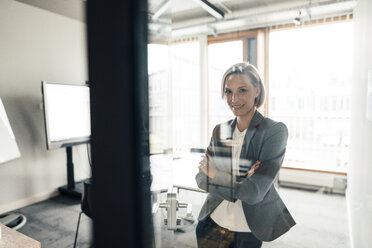 Female entrepreneur with arms crossed standing in office - JOSEF04807