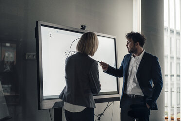 Professional team working together on projection screen at office - JOSEF04820