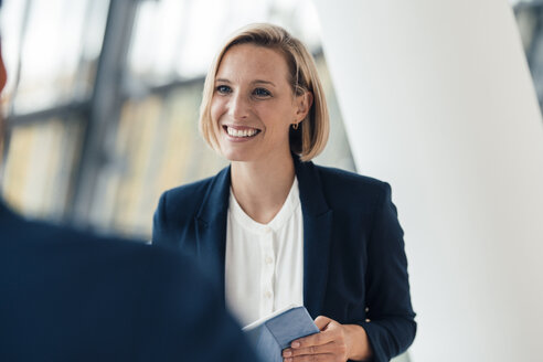 Businesswoman having discussion with colleague at office - JOSEF04870