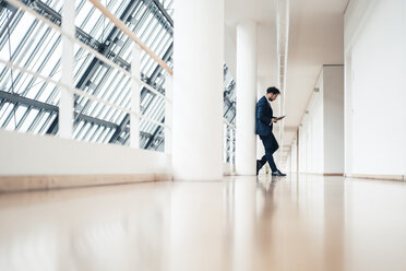 Male entrepreneur using digital tablet while standing in office - JOSEF04922