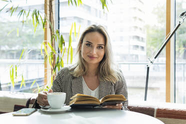 Female freelance worker having coffee at cafe - PNAF01966