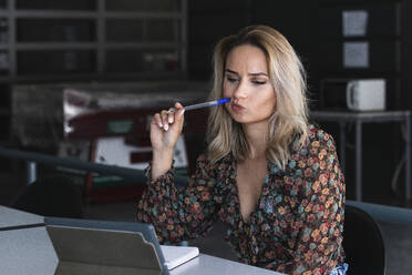 Thoughtful female freelancer using digital tablet in cafe - PNAF01982