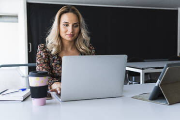 Businesswoman working on laptop at desk office - PNAF02012