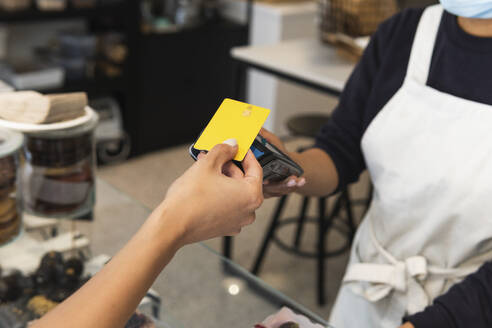 Frau zahlt mit Kreditkarte an Café-Besitzerin - PNAF02025