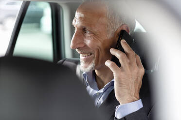 Male professional talking on smart phone while sitting in car - EIF01368