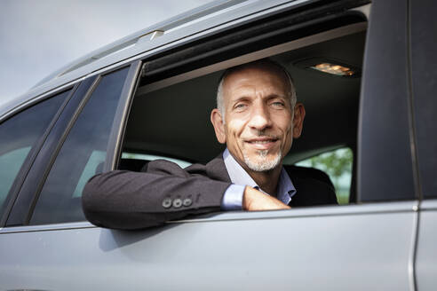 Geschäftsmann schaut aus dem Fenster, während er im Auto sitzt - EIF01377