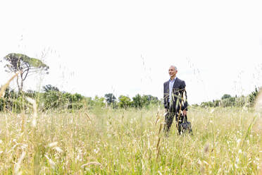 Male professional in businesswear standing in grassy field - EIF01391