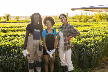 Lächelnde Bäuerinnen mit Mädchen auf einem Bio-Bauernhof an einem sonnigen Tag - OIPF01065