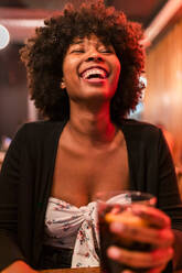 Happy Afro woman at bar - JRVF01149