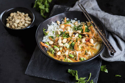 Gelbes Thai-Curry in einer Schüssel mit Stäbchen auf dem Tisch - SBDF04493