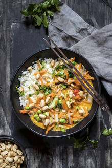 Thai-Curry garniert mit Erdnuss auf Holztisch - SBDF04494