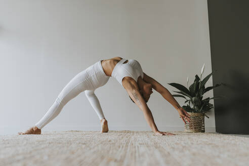 Flexibler Yogi beim Üben, während er sich im Yogastudio nach hinten beugt - OCAF00657