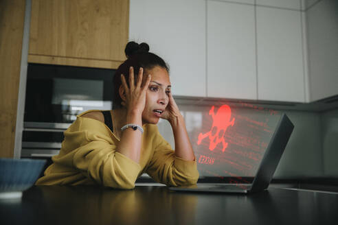 Frau mit Kopf in den Händen schaut auf Gefahrensymbol Laptop - LIFIF00047